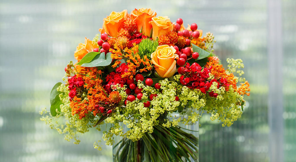 Hochwertiger, schöner Strauß mit Rosen in den Farben Gelb, Orange, Rot und Grün. Floristik und Sträuße kreiert von der Gärtnerei Konzelmann-Höefer.