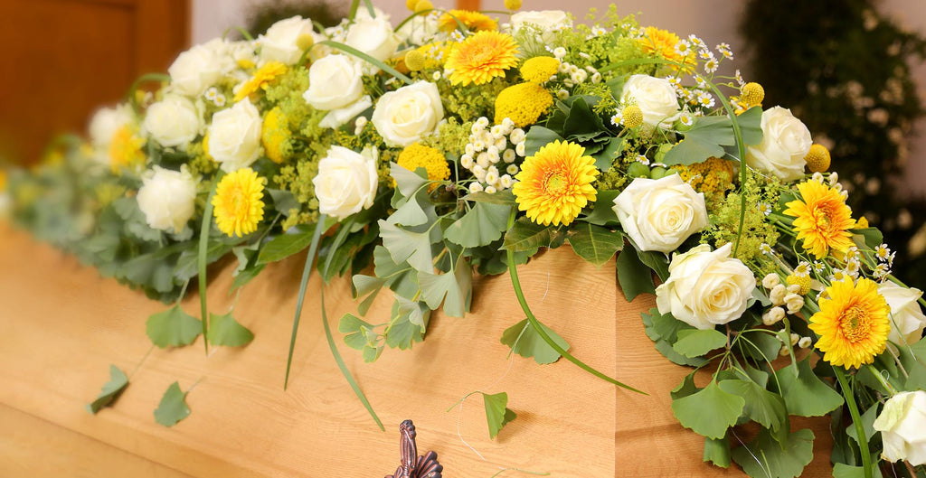 Trauerfloristik, Sargbouquet, mit weißen Rosen und gelben Gerbera. Raumschmuck, Beerdigung, Sarg, Hoffnung, Frieden